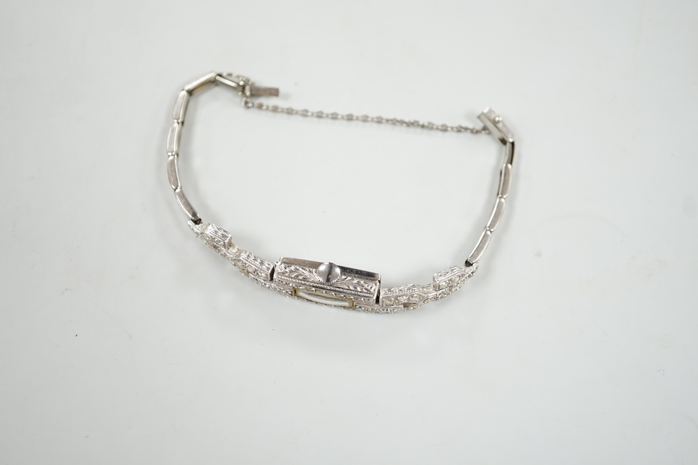 A lady's platine and diamond cluster set manual wind cocktail watch, with rectangular Arabic dial, on a white metal expanding bracelet, 16cm, gross weight 15 grams.